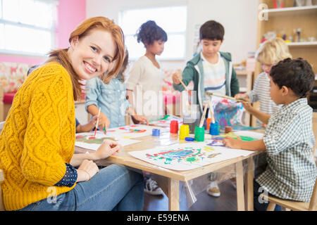 Teacher and students painting in classroom Stock Photo