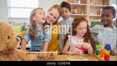 Students and teacher playing in classroom Stock Photo
