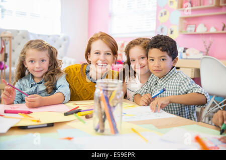 Students and teacher smiling in classroom Stock Photo