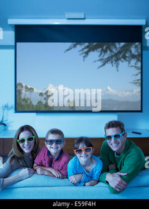 Family watching 3D television in living room Stock Photo