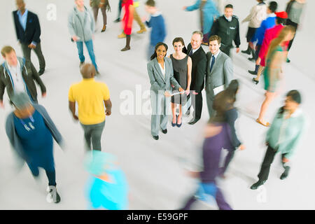 Portrait of business people among bustling crowd Stock Photo