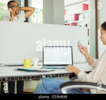 People using cell phones in office Stock Photo