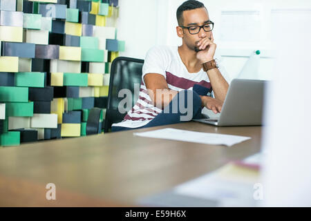 Man using laptop in office Stock Photo