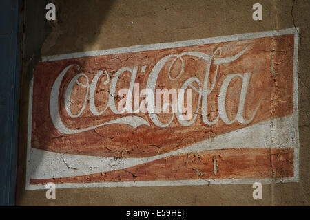 Old weathered Coca Cola logo painted on a wall. Place an abandoned bottling plant in Tychy, Poland. Stock Photo