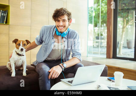 Man petting dog in office Stock Photo