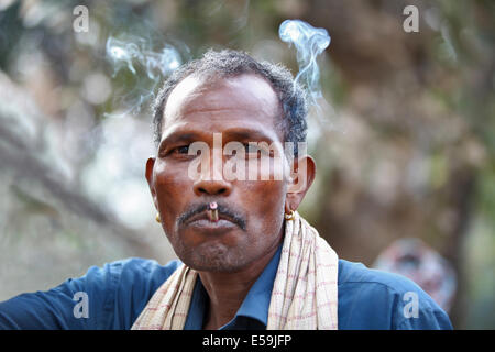 A man smoking a Bidi cigarette that is handmade with newspaper and sold ...