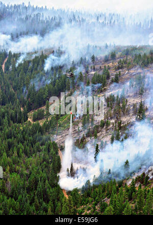 Aerial view of an Oregon Army National Guard CH-47 Chinook helicopter dropping water on a fire in support of suppression efforts at the Logging Unit fire July 20, 2014 near Madras, Oregon. Record wildfires have swept across the northwest claiming lives and destroying thousands of acres of forest. Stock Photo