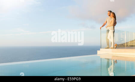 Couple overlooking ocean from modern balcony Stock Photo