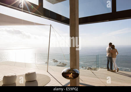 Couple standing on balcony of modern home Stock Photo