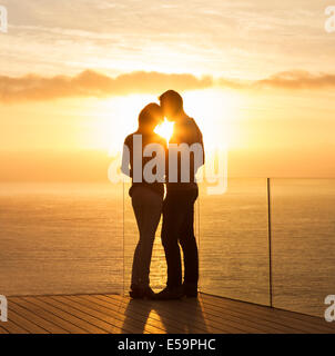 Silhouette of couple at sunset over ocean Stock Photo