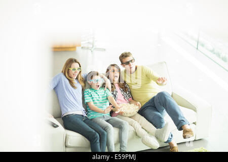 Family watching 3D television in living room Stock Photo