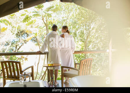 Couple in bathrobes standing in outdoor spa Stock Photo