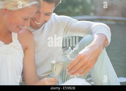 Couple toasting each other with champagne outdoors Stock Photo