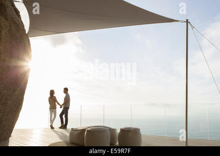 Couple standing on modern balcony Stock Photo
