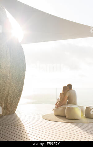 Couple relaxing together on modern balcony Stock Photo