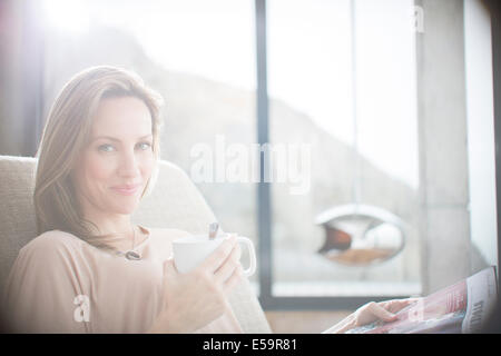 Woman having cup of coffee on sofa Stock Photo