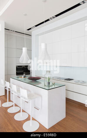 Bar stools at counter in modern kitchen Stock Photo