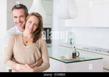 Couple hugging in modern kitchen Stock Photo