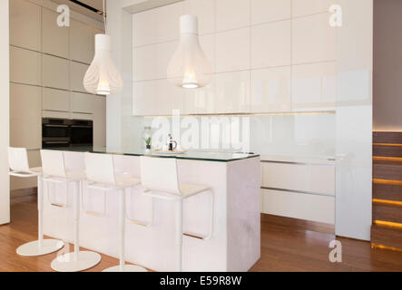 Bar stools at counter in modern kitchen Stock Photo