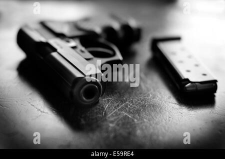 Closeup of powerful handgun with bullets on old wooden surface Stock Photo