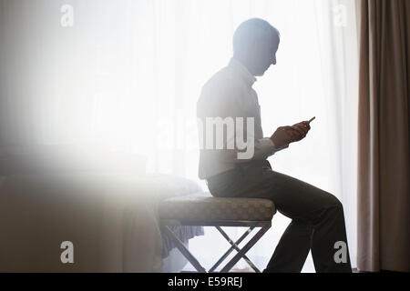 Silhouette of man using cell phone Stock Photo