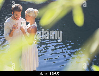 Couple drinking champagne by pool Stock Photo