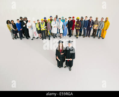 Portrait of graduates with workers in background Stock Photo