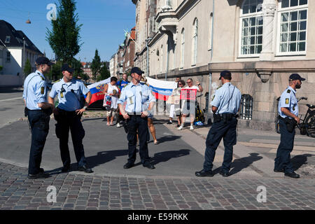 Copenhagen, Denmark. 24th July, 2014.  As demonstrators gather in front of the Russian embassy in Copenhagen protesting against what they claim is Russian aggressive interference in Eastern Ukraine, a small pro-Russian counter demonstration took place. On the photo Danish police forms a line between the ant-i Russian and pro-Russian demonstrators in order to keep them apart. The red sign (photo, right) reads: 'Save Donbass People'. Credit:  OJPHOTOS/Alamy Live News Stock Photo