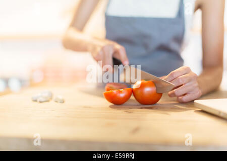 Woman chopping vegetables in kitchen Stock Photo