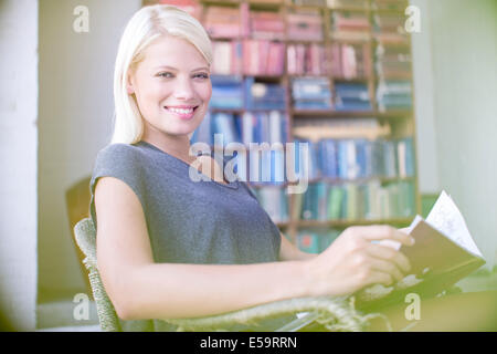 Woman reading in armchair Stock Photo