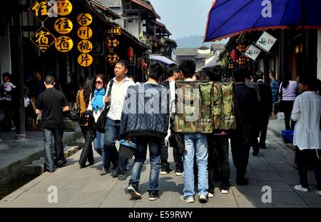 JIE ZI ANCIENT TOWN, CHINA:  A group of students with backpacks walking along busy Jiangcheng Street Stock Photo