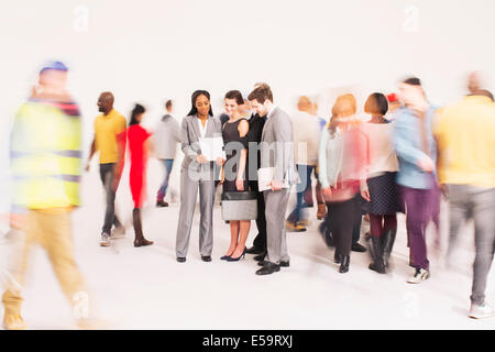 Bustling crowd around business people Stock Photo