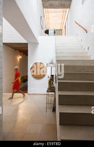 Woman walking by doorway in modern house Stock Photo