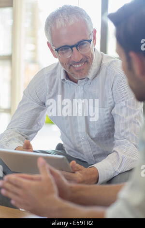Businessmen talking in office Stock Photo