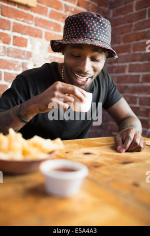 African American man having drink in restaurant Stock Photo