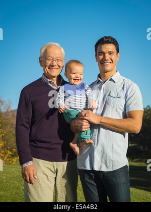 Three generations of men smiling together outdoors Stock Photo