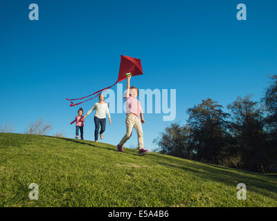 Mother and children flying kite in park Stock Photo