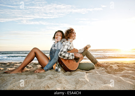 Couple relaxing together on beach Stock Photo