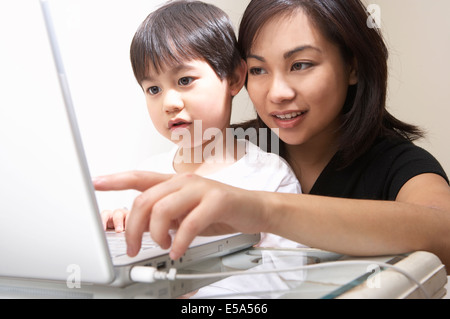 Filipino mother and son using laptop together Stock Photo