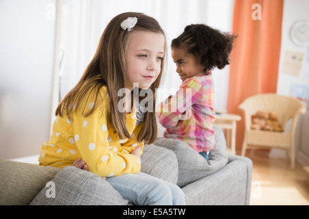 Girls fighting on sofa Stock Photo
