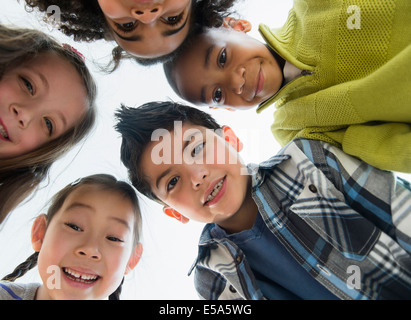 Children smiling in huddle Stock Photo