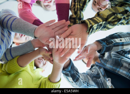 Children cheering in huddle Stock Photo