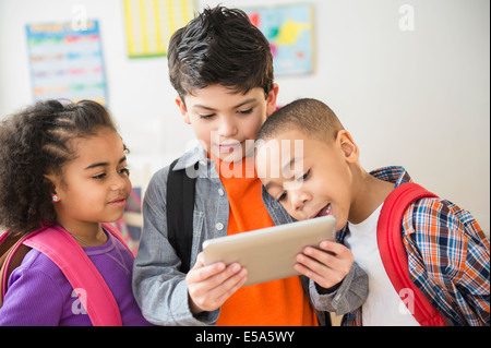 Students using digital tablet in classroom Stock Photo