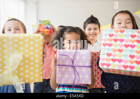 Children holding birthday presents at party