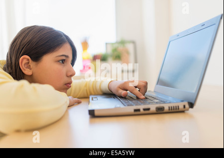 Hispanic girl using laptop at desk Stock Photo