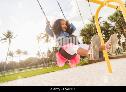 Mixed race girl playing on playground Stock Photo