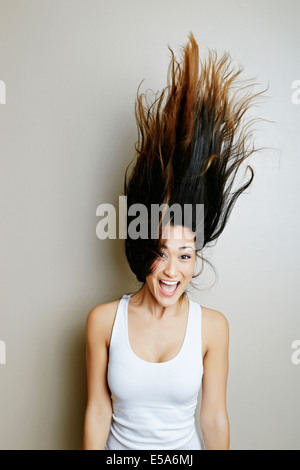 Mixed race woman tossing her hair Stock Photo