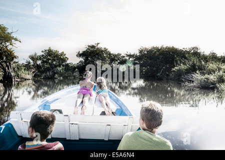 Children riding in canoe on rural lake Stock Photo