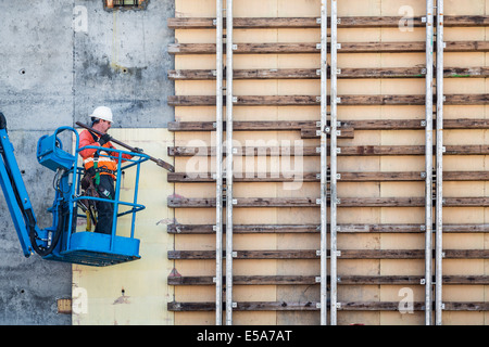 Caucasian worker on boom lift working on construction site Stock Photo