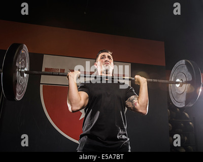 Caucasian man lifting weights in gym Stock Photo